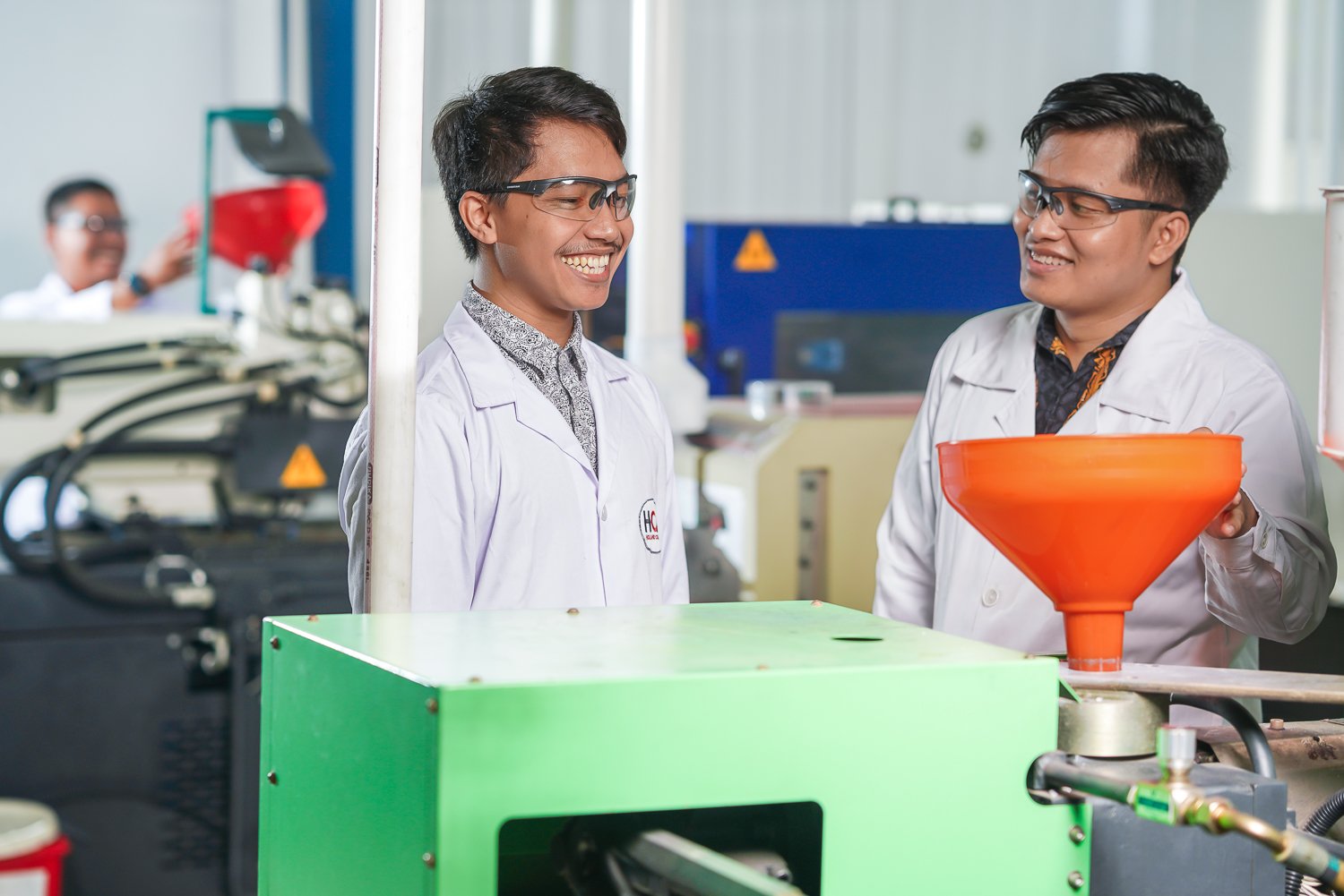 Two Holland Colours operation employees smiling and collaborating