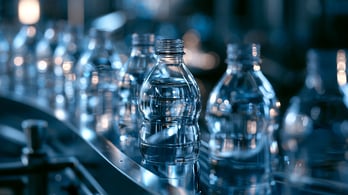 r0nr0n1_63471_Clear_PET_bottles_progressing_through_a_modern__17b4fe7e-c8cd-40ac-bfb4-a214d18e72b1_0